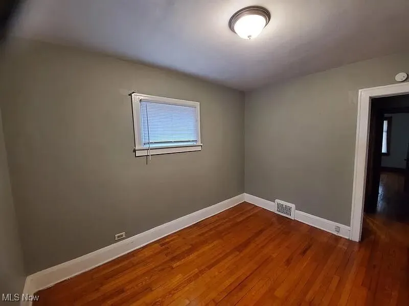 Unfurnished room featuring dark wood-style floors