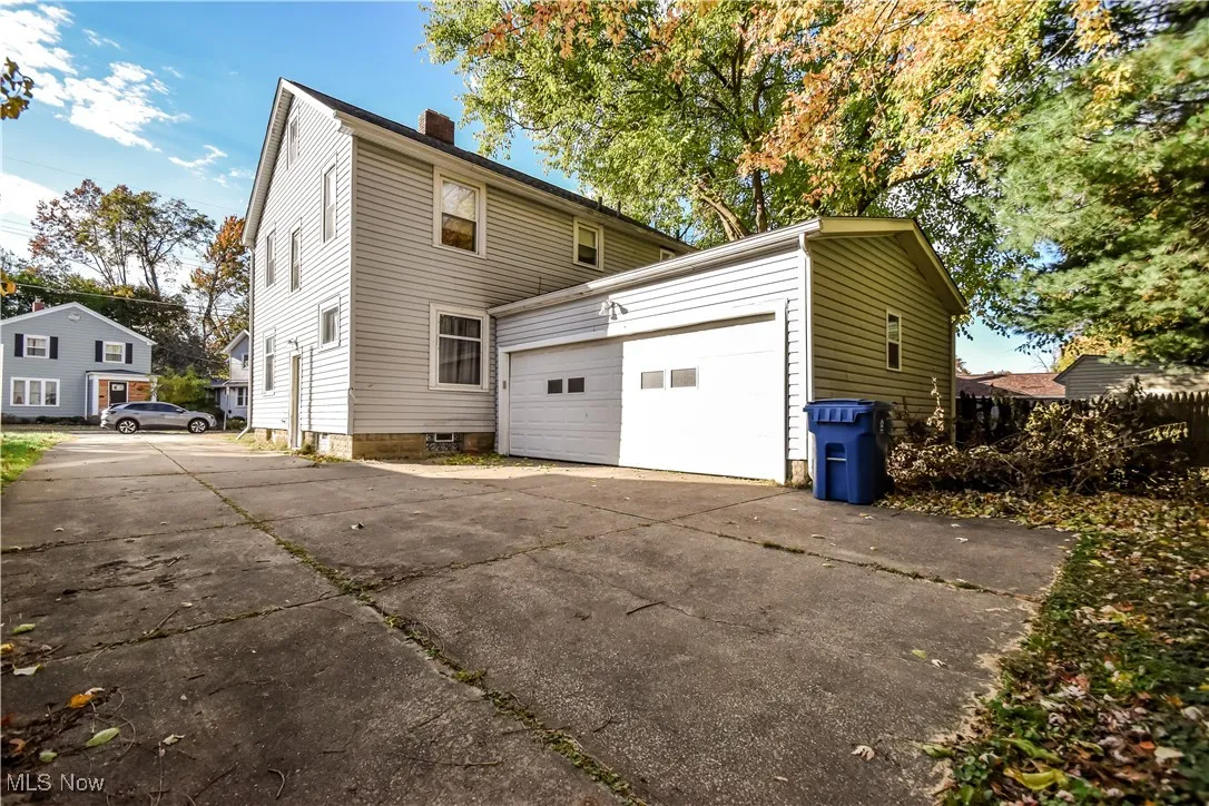 View of side of home featuring a chimney and driveway
