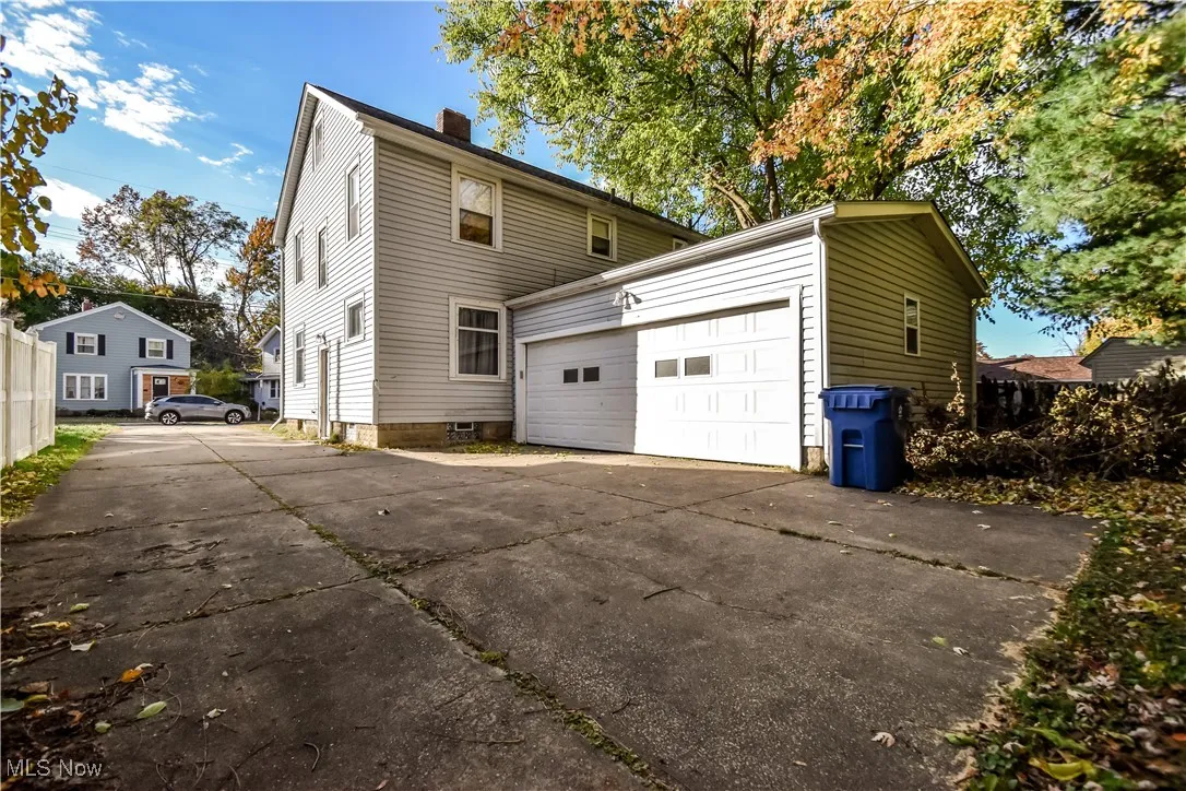 View of side of home with a chimney and driveway