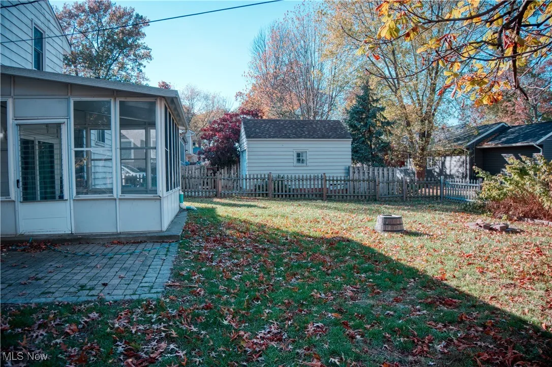 Fenced backyard featuring a sunroom
