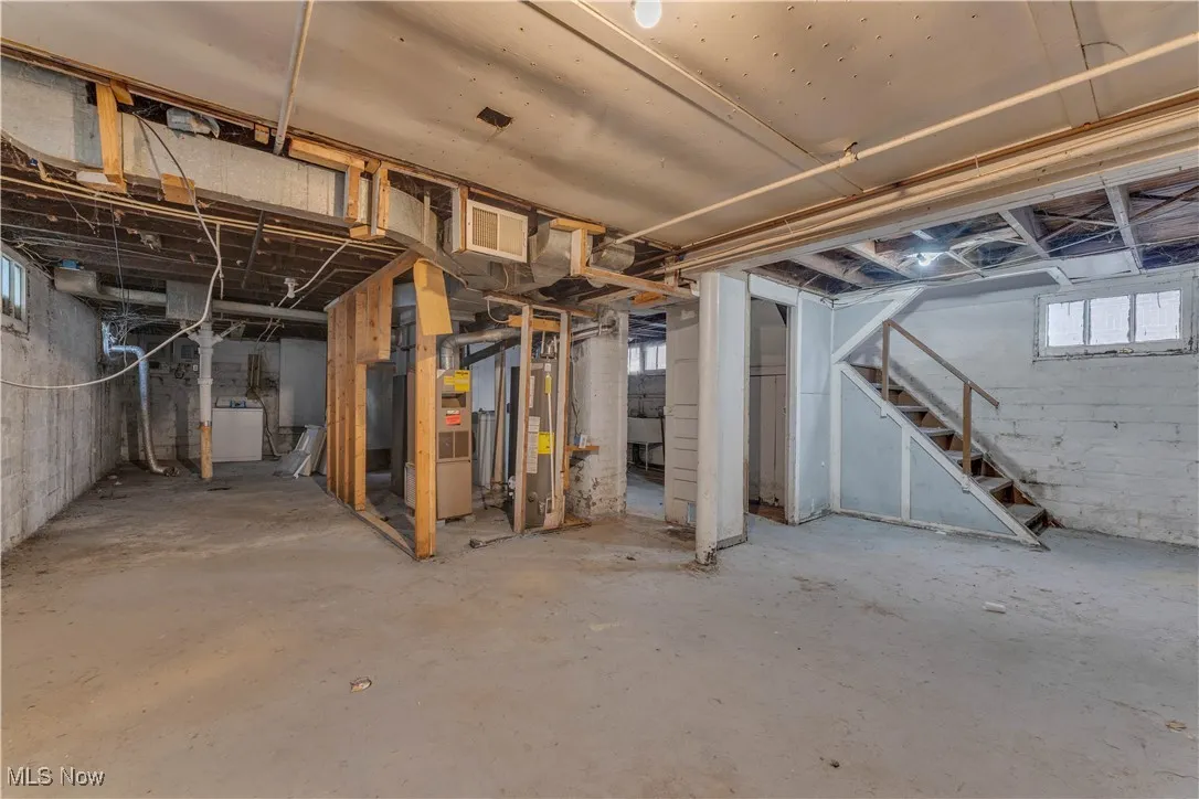 Below grade area with stairs, washer / clothes dryer, heating unit, and gas water heater