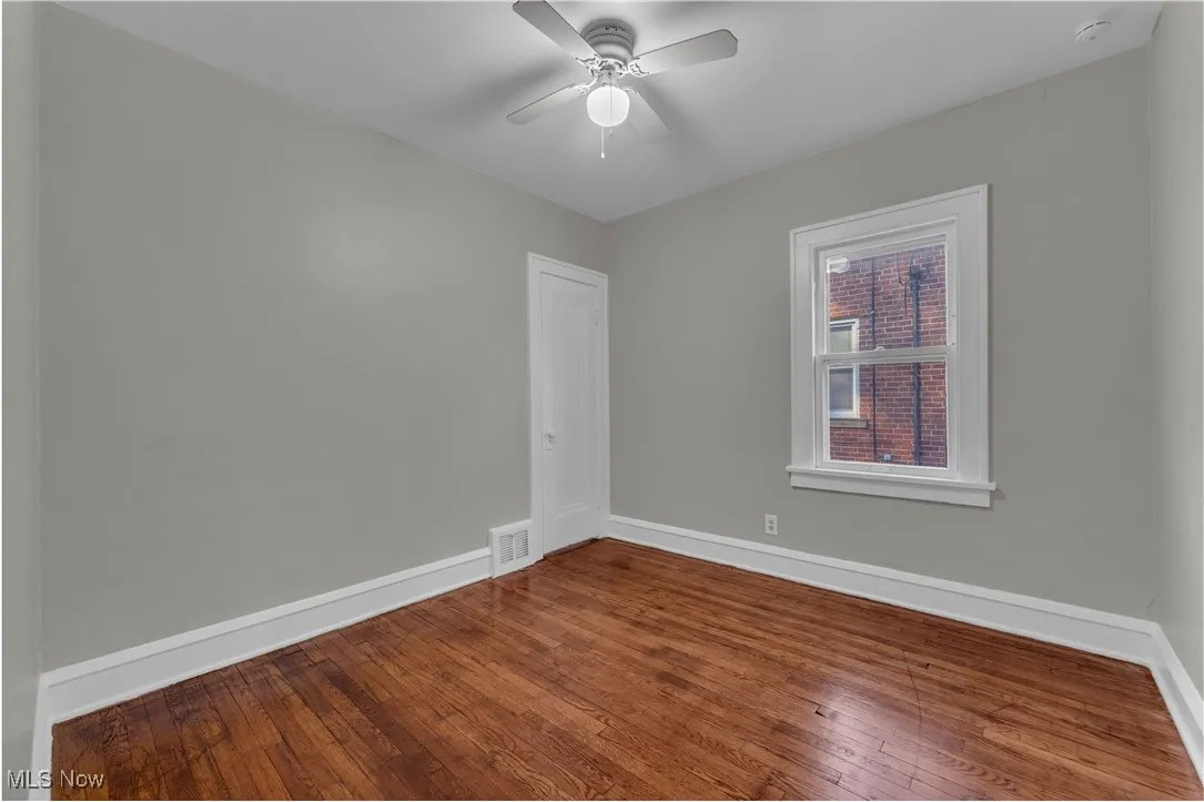 Empty room featuring hardwood / wood-style flooring and a ceiling fan