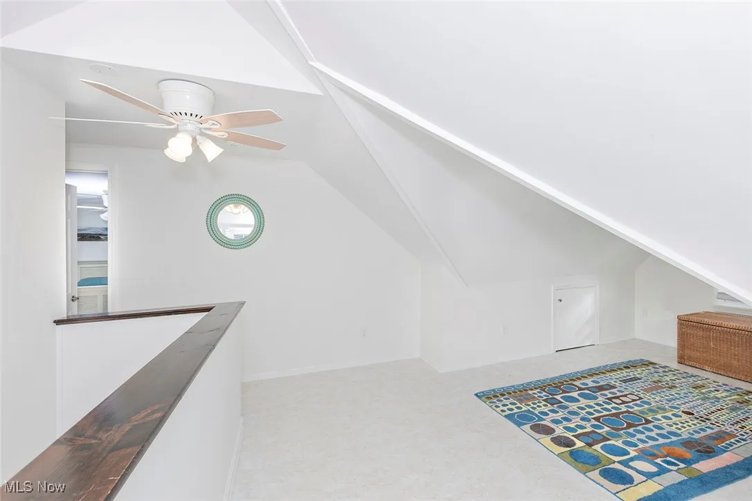 Additional living space featuring lofted ceiling and ceiling fan