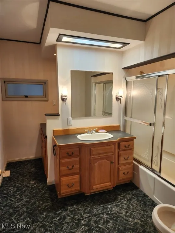 Bathroom with combined bath / shower with glass door and vanity