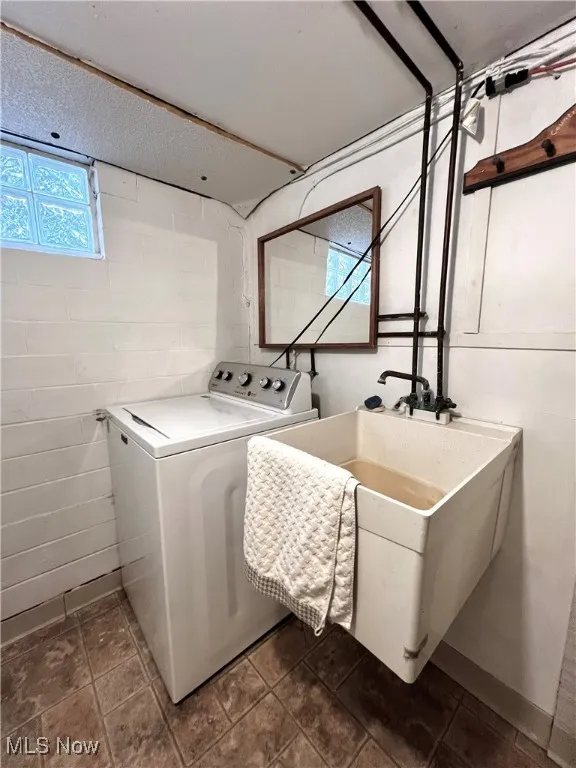 washer location in bathroom area with sink and shower