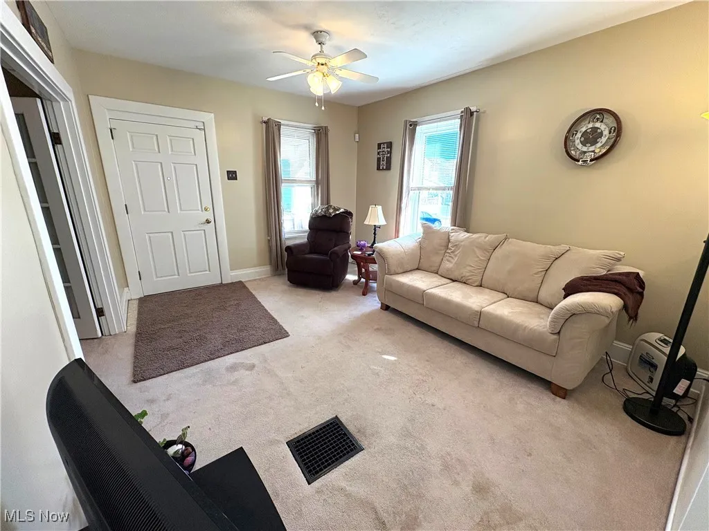 Living room with carpet and ceiling fan