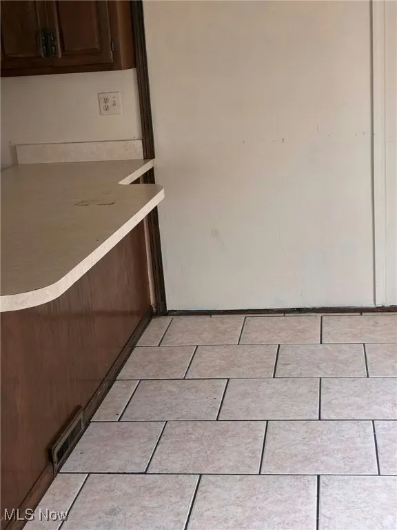 Detailed view of light countertops and dark brown cabinetry