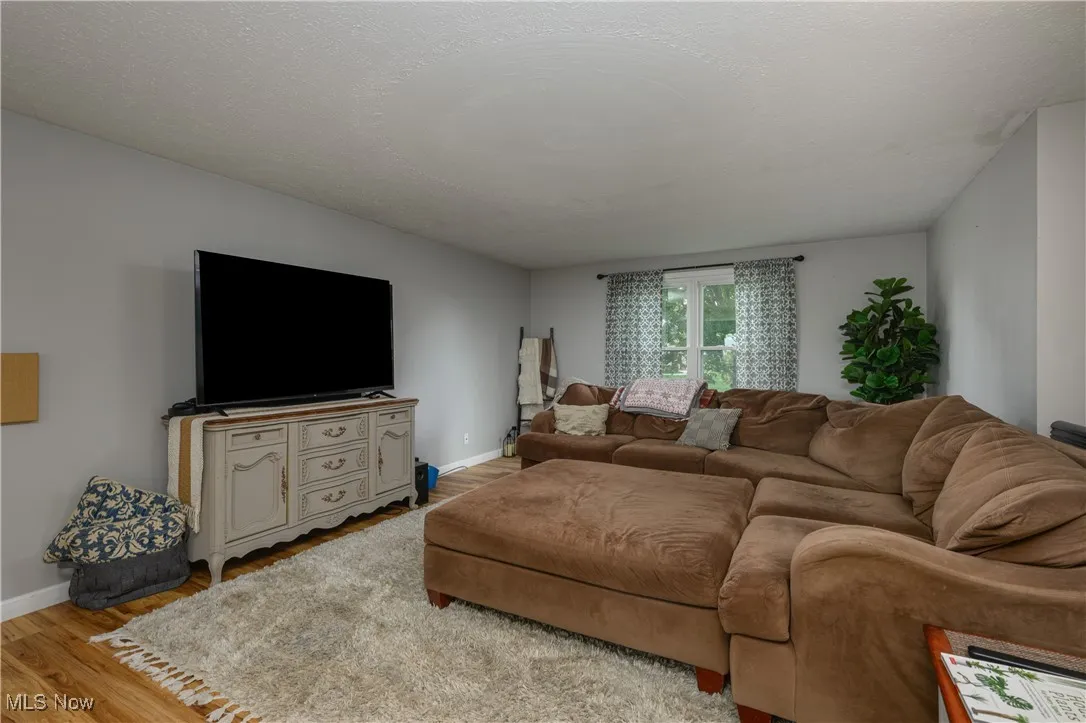 Living area with wood finished floors and a textured ceiling