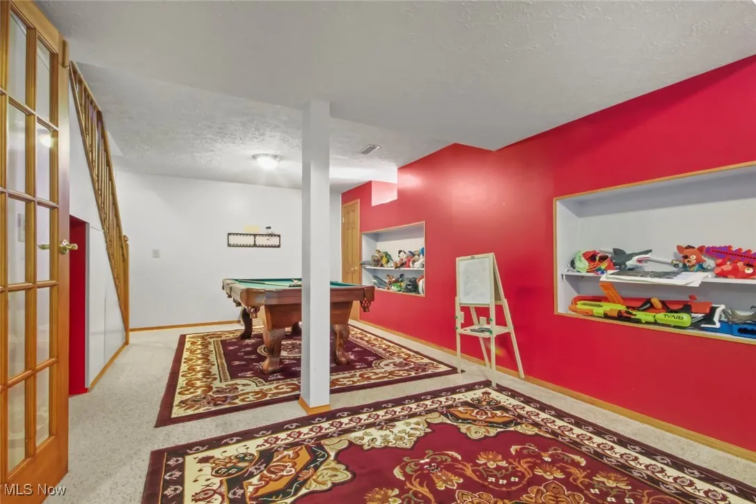 Recreation room with a textured ceiling and billiards