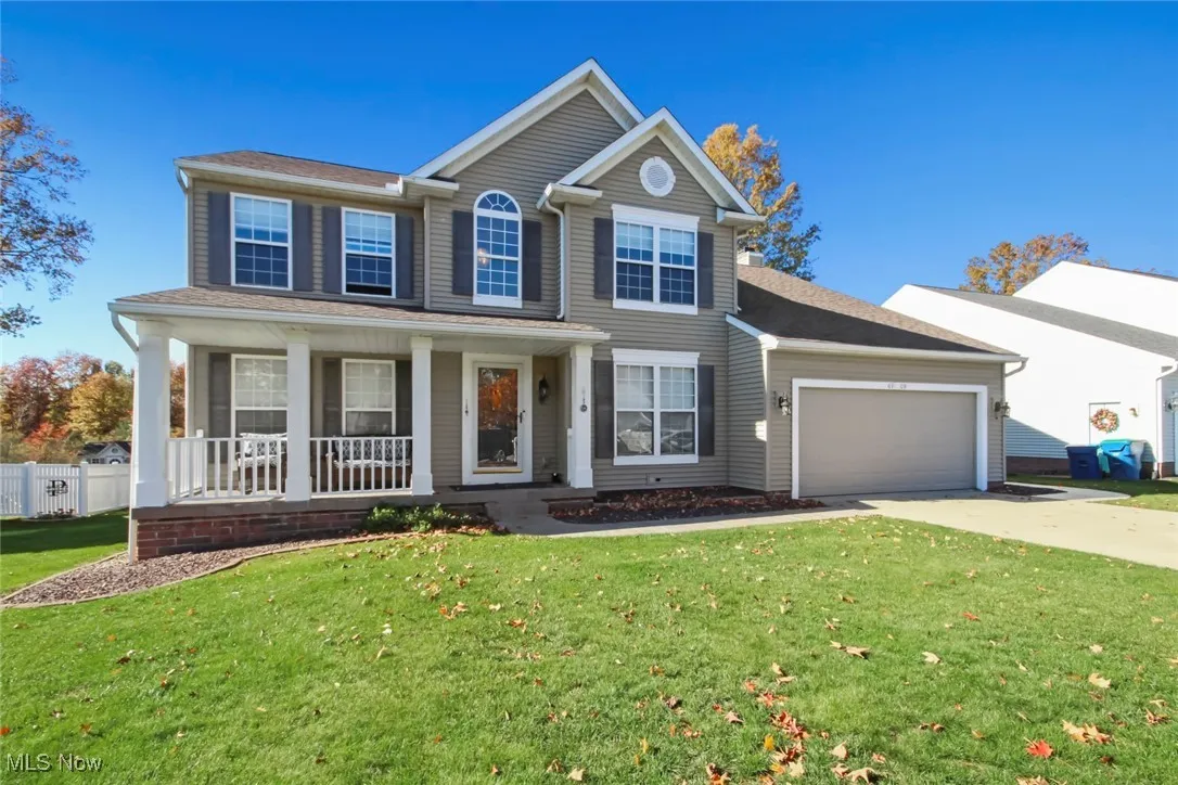 View of front of home with concrete driveway, a porch, an attached garage, and a shingled roof