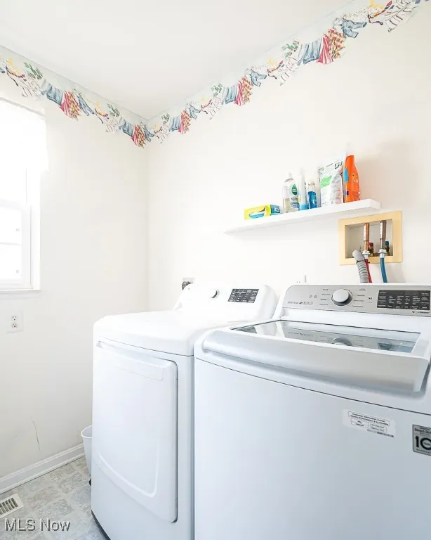 Washroom featuring washer and clothes dryer and baseboards