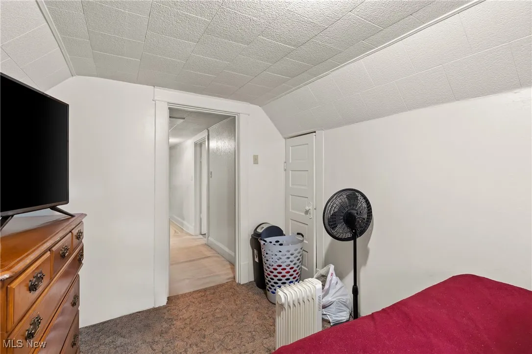 Bedroom featuring lofted ceiling and carpet flooring