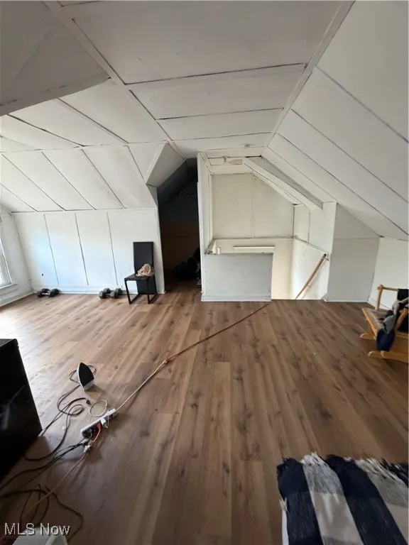 Additional living space with wood finished floors and lofted ceiling