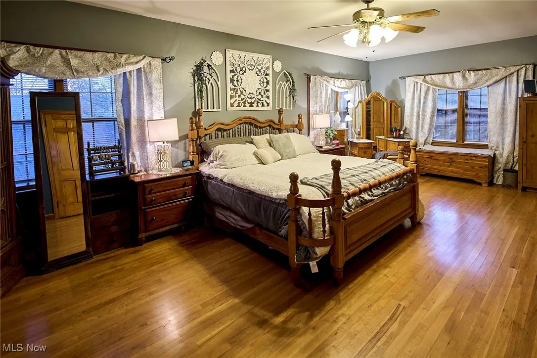 Bedroom with hardwood / wood-style floors and a ceiling fan