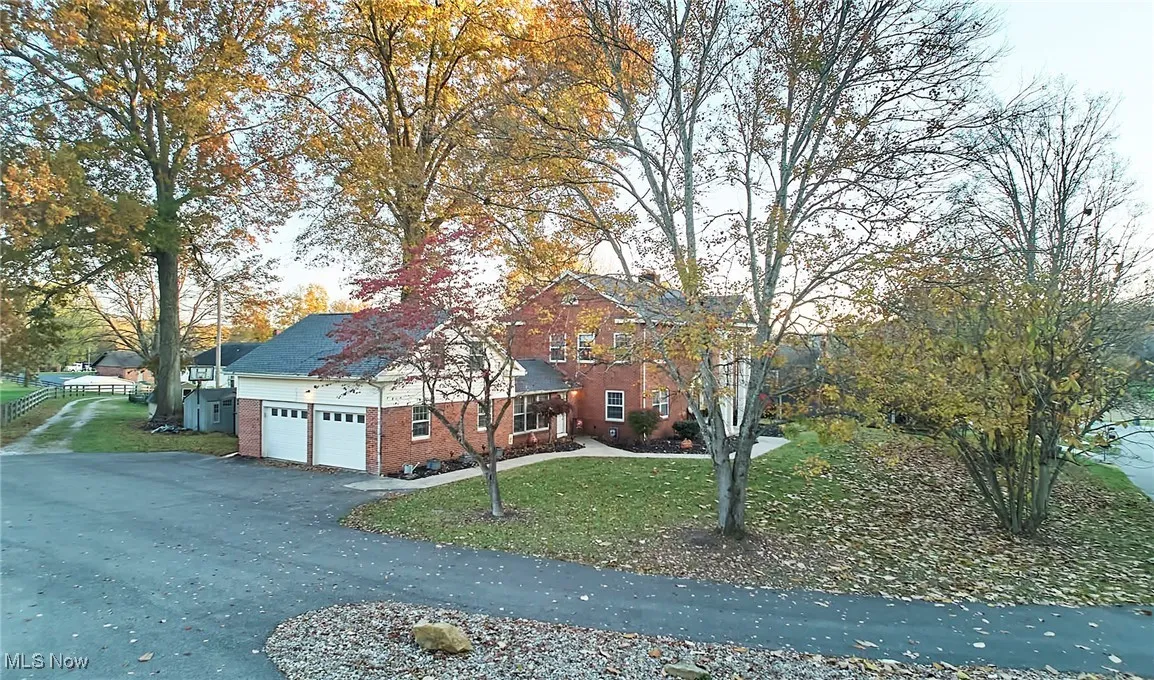 View of front of house featuring brick siding, a front yard, asphalt driveway, and an attached garage