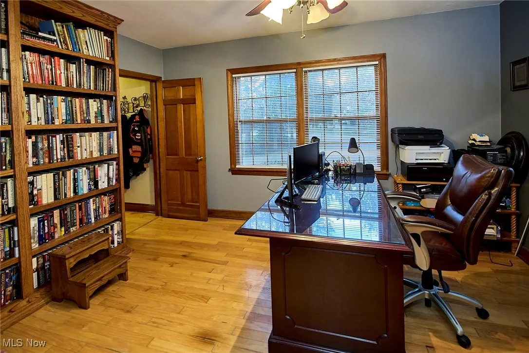 Office space with light wood finished floors and a ceiling fan