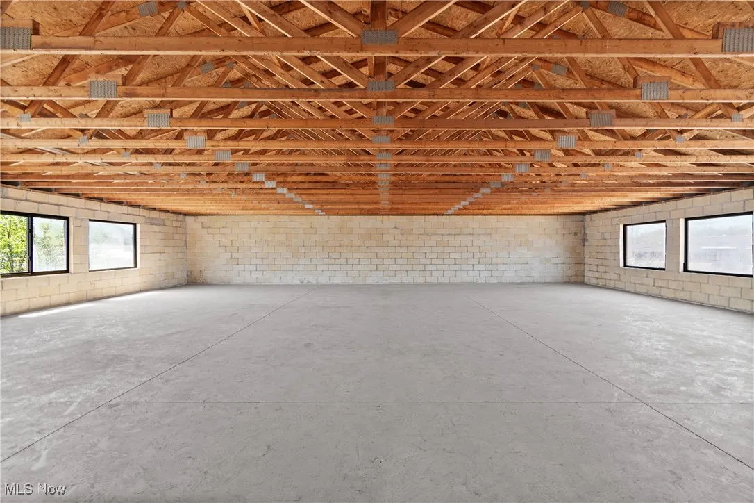 Misc room with concrete floors, concrete block wall, and a garage