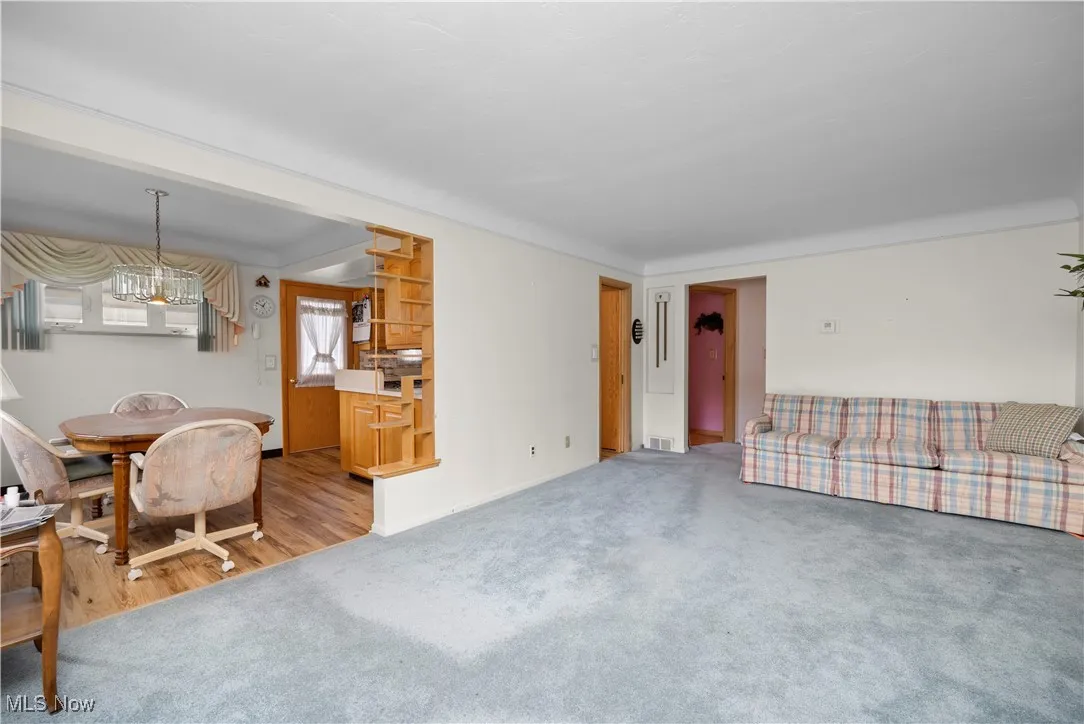 Carpeted living room features large picture window and lots of natural light