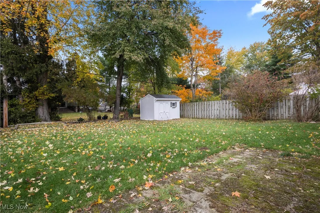 Partially fenced backyard with a shed