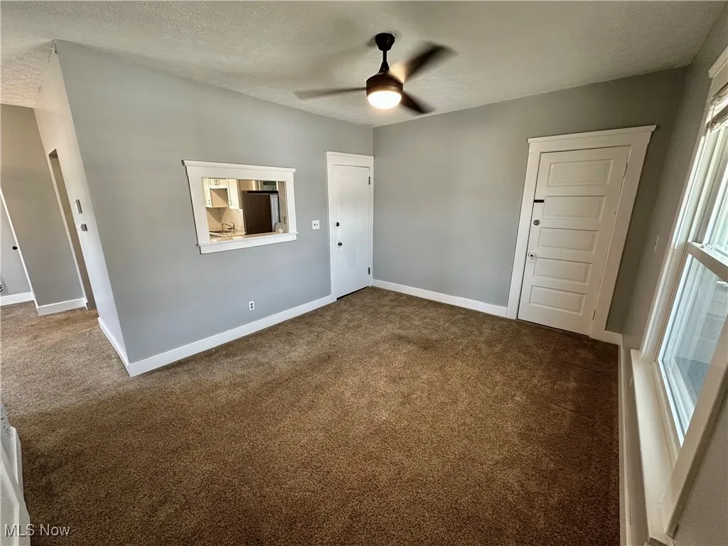 Spare room featuring carpet, a textured ceiling, and ceiling fan