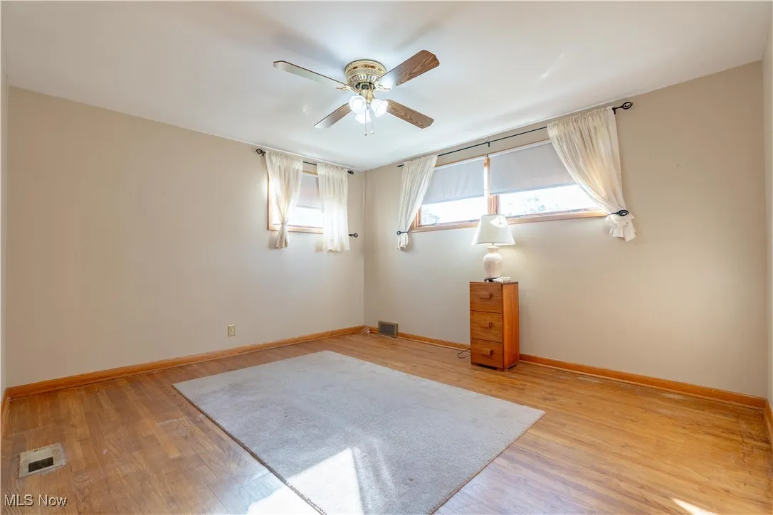 Empty room with light wood-style flooring and a ceiling fan
