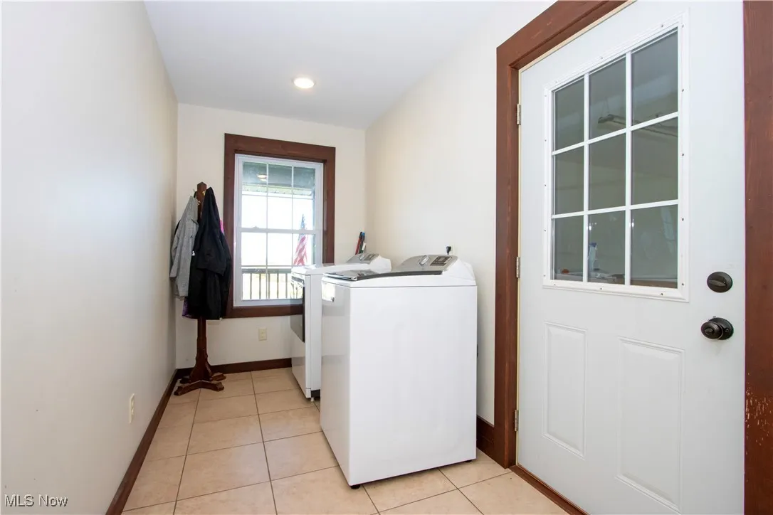 Laundry room with light tile patterned floors and separate washer and dryer
