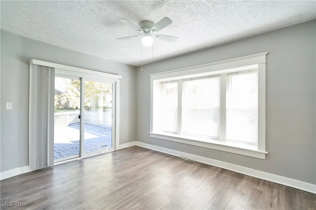 Dining room featuring a textured ceiling, light wood-style floors, and ceiling fan
