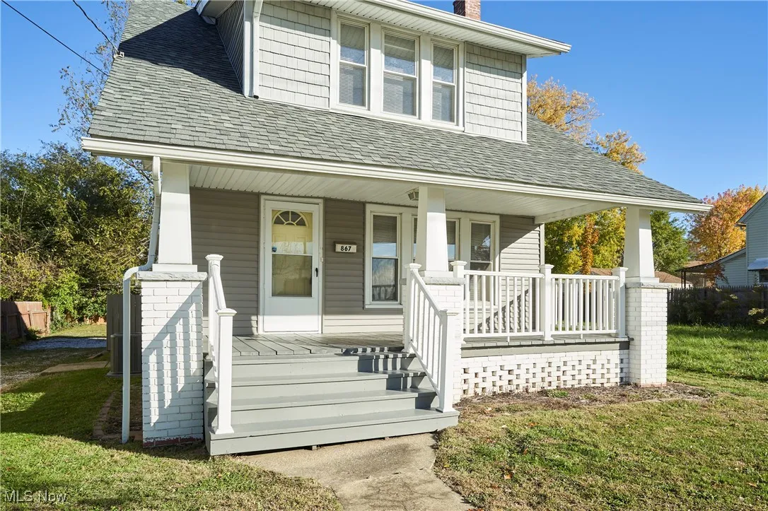 View of front of home with a porch, a shingled roof, and a chimney