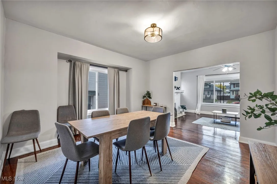 Dining area with dark wood-style flooring and ceiling fan