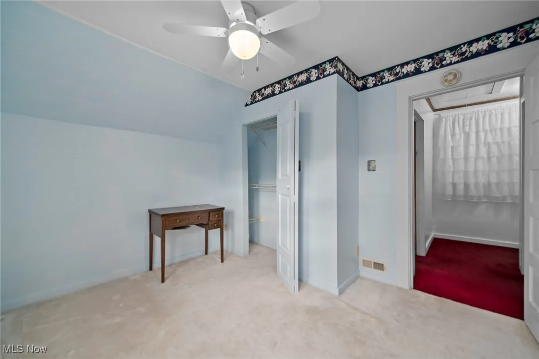 Additional living space with attic access, carpet, lofted ceiling, and ceiling fan