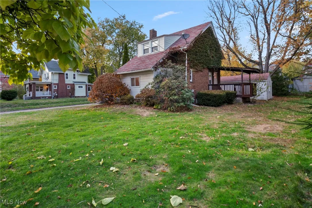 View of home's exterior with a chimney and a yard