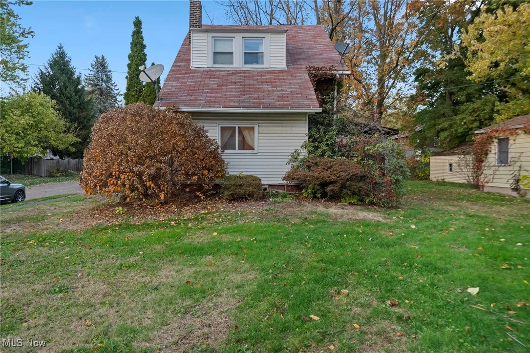 View of side of property with a yard and a chimney