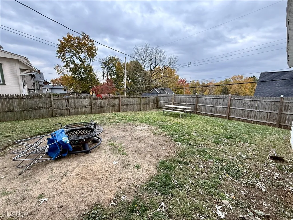 Fenced backyard with an outdoor fire pit