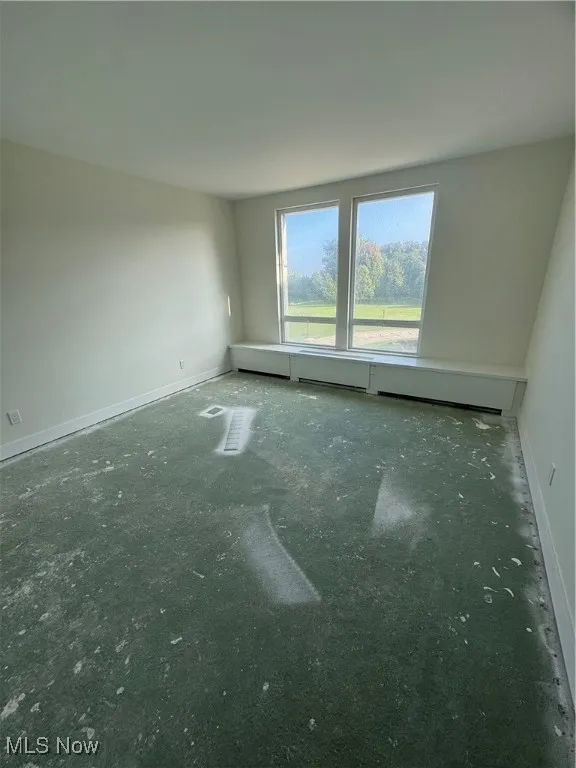 Spare room with baseboards and a baseboard radiator