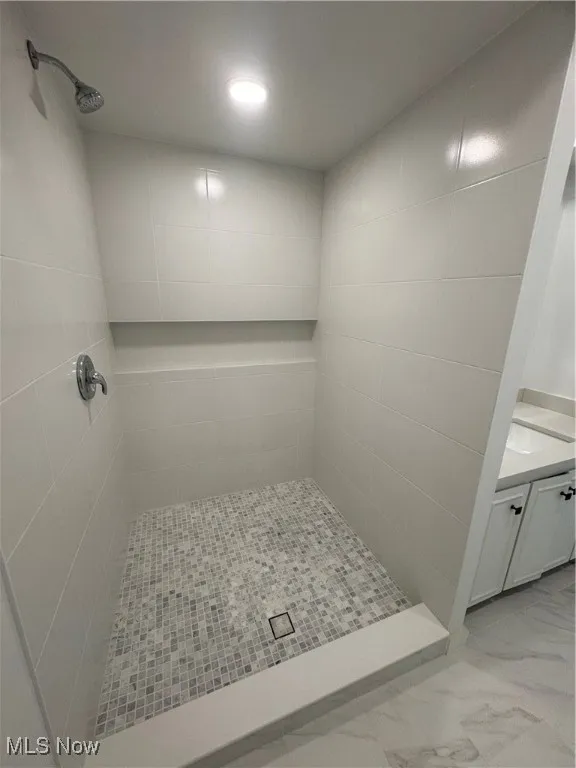 Bathroom featuring a shower stall, vanity, light marble finish flooring, and recessed lighting
