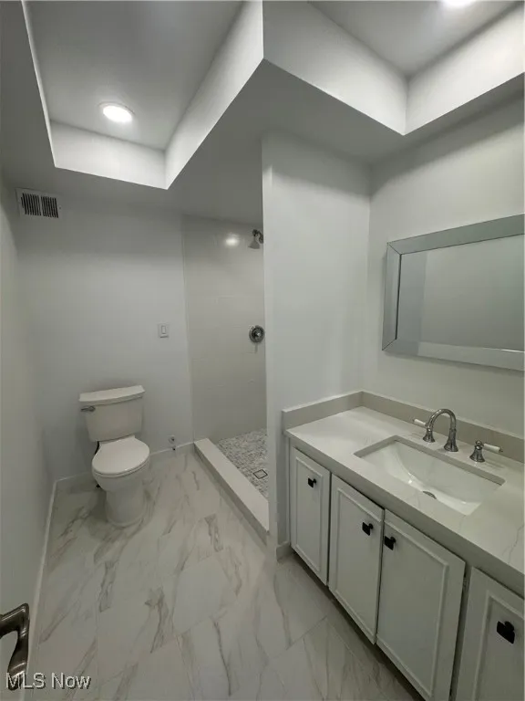 Full bathroom with a stall shower, vanity, recessed lighting, light marble finish flooring, and a raised ceiling