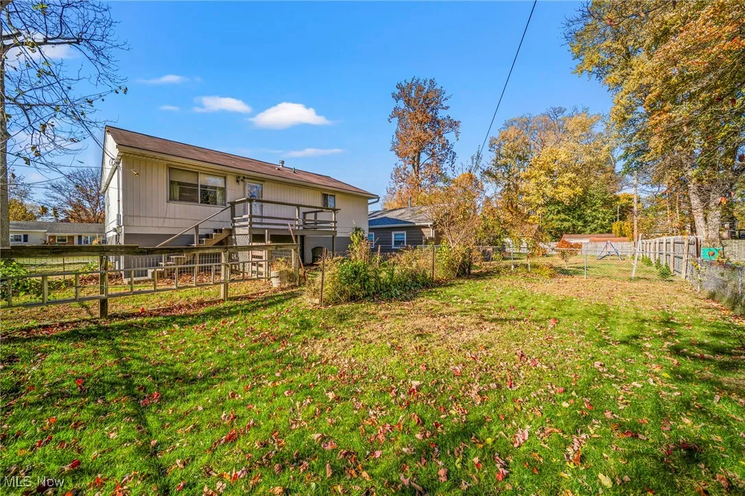 Rear view of property featuring a fenced backyard,  and a deck