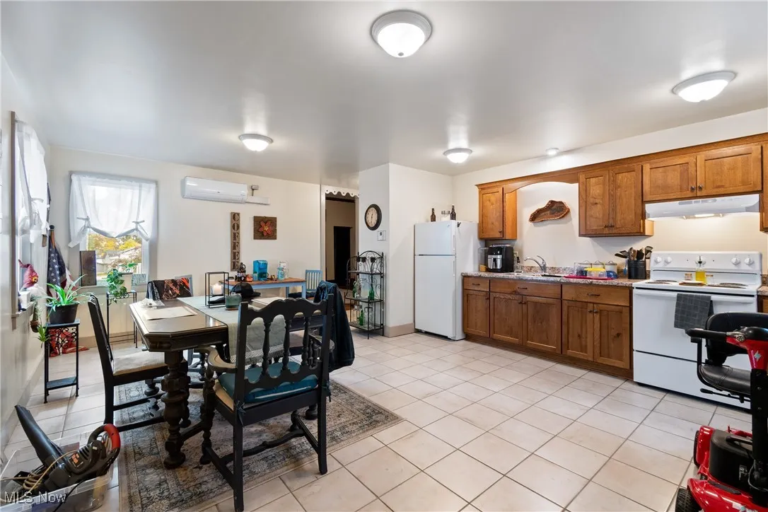 Dining space with light tile patterned flooring and a wall mounted air conditioner