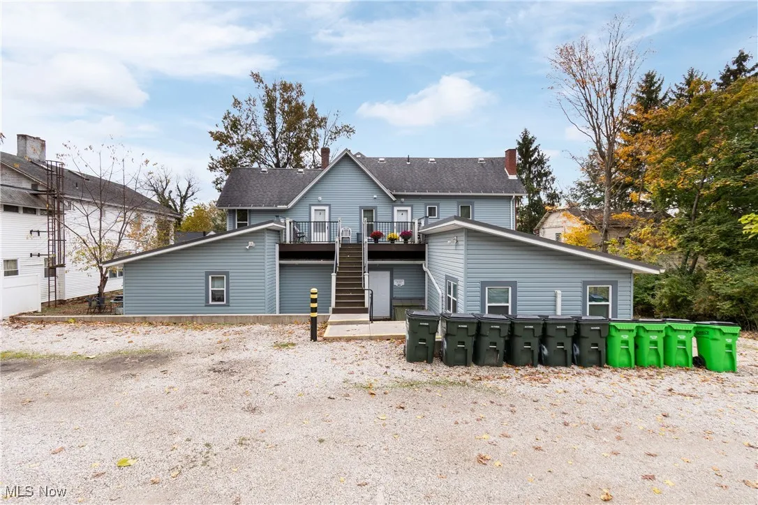 Rear view of property featuring stairway and a deck