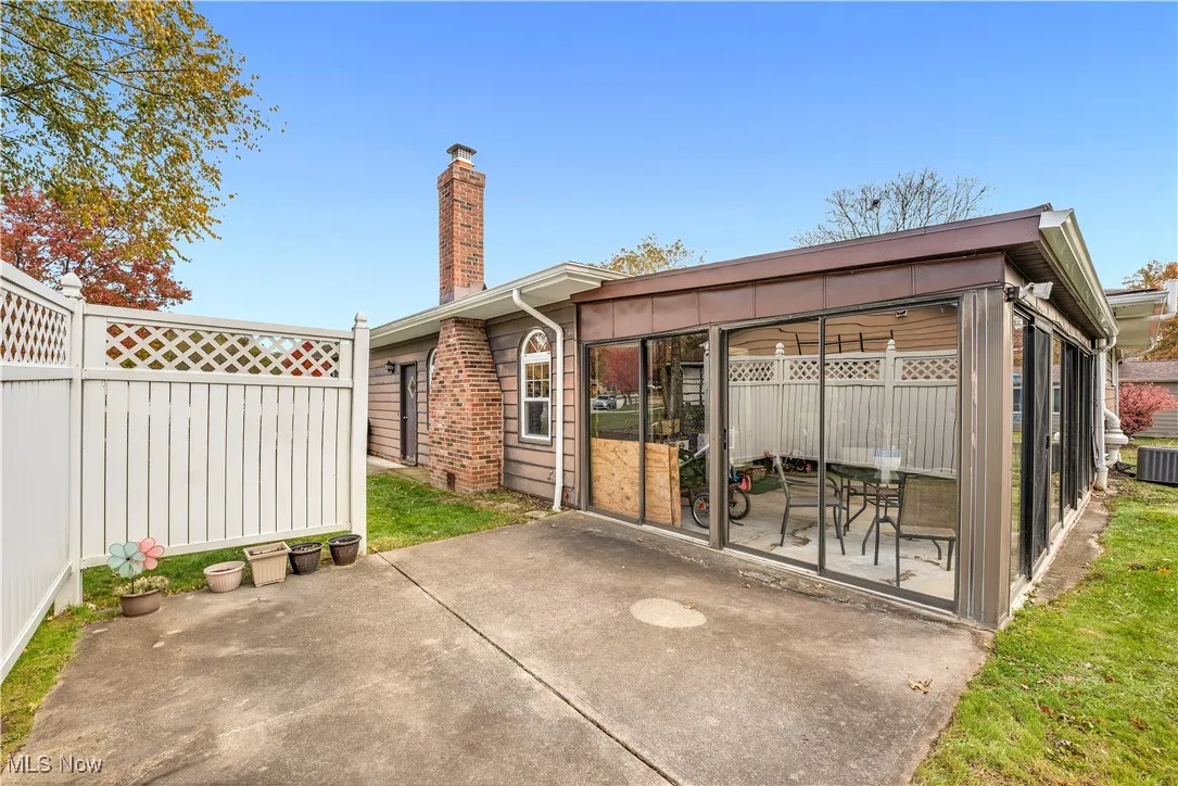 Rear view of property featuring a chimney and a patio