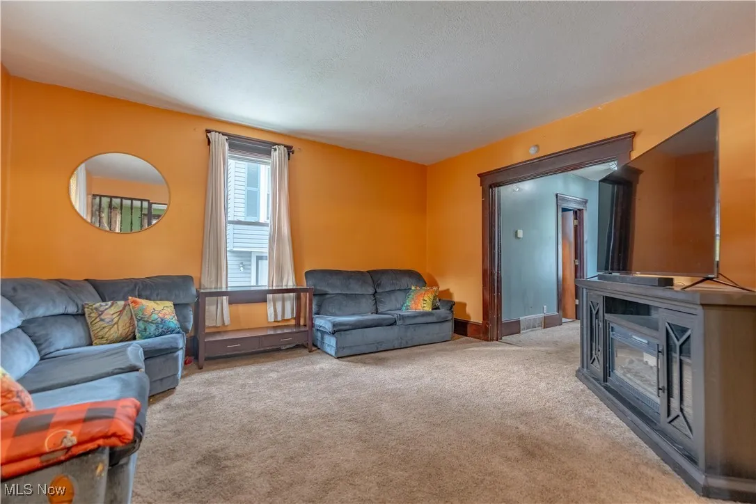 Living area with light colored carpet and a textured ceiling