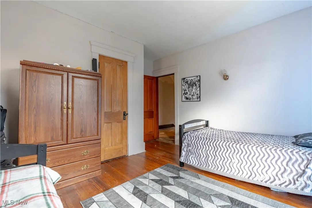 Bedroom with wood finished floors and a closet