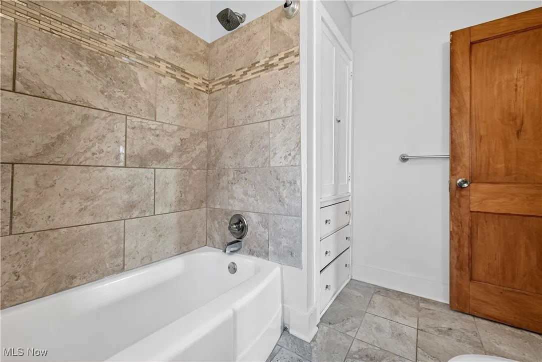 Full bathroom with baseboards and shower / washtub combination