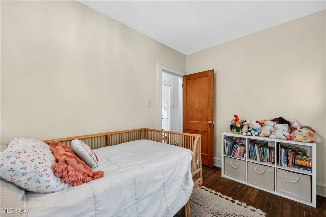Bedroom with dark wood-style flooring and baseboards