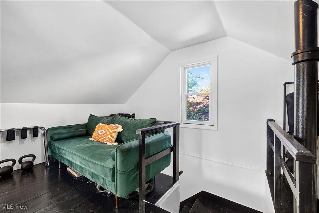 Bedroom featuring vaulted ceiling and dark wood-style flooring
