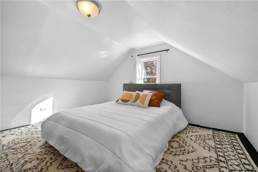 Bedroom featuring vaulted ceiling and baseboards