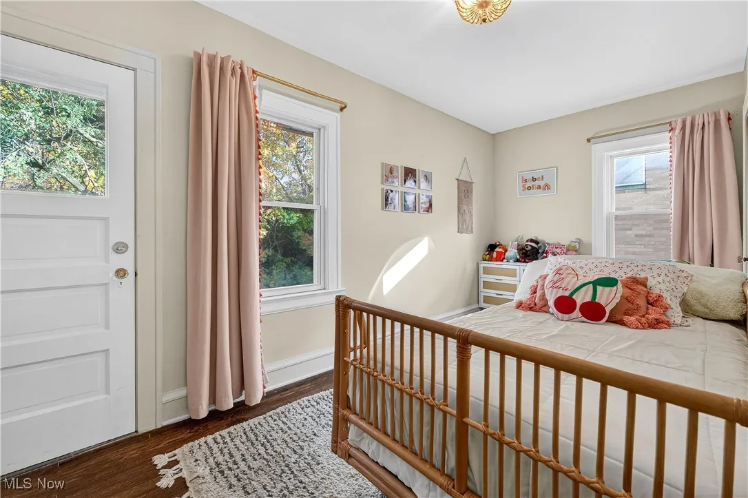 Bedroom featuring dark wood-type flooring and baseboards