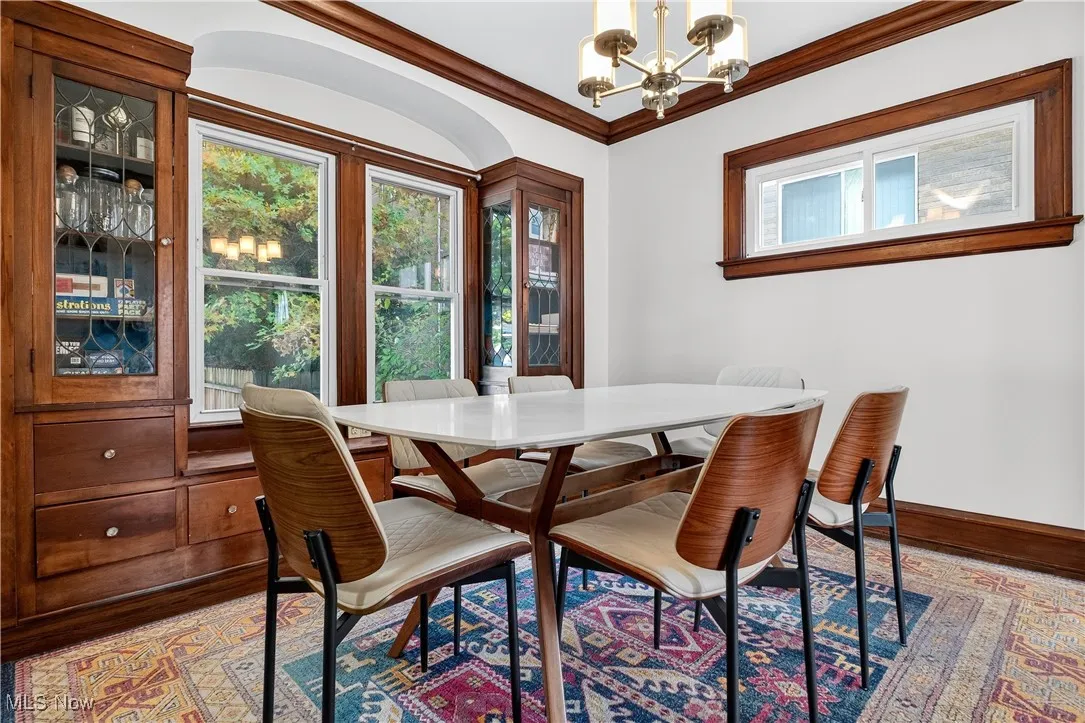 Dining room featuring a chandelier, ornamental molding, and wood finished floors