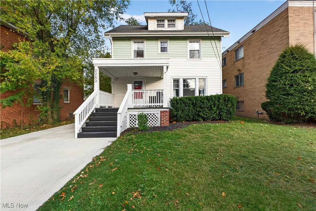 Traditional style home with covered porch and a front lawn