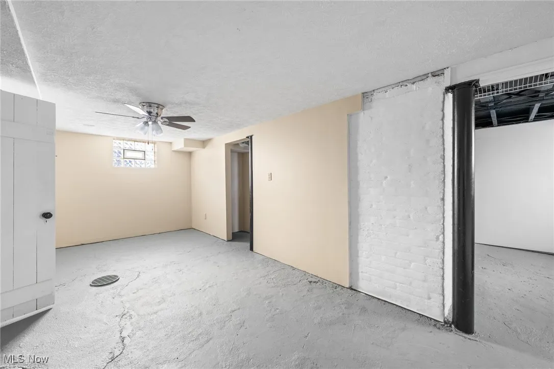 Empty room featuring concrete flooring, a textured ceiling, and ceiling fan